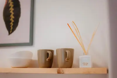 a shelf with three coffee cups on it at Airport Lux Balice in Szczyglice