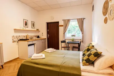 a small room with a bed and a kitchen at Airport Lux Balice in Szczyglice