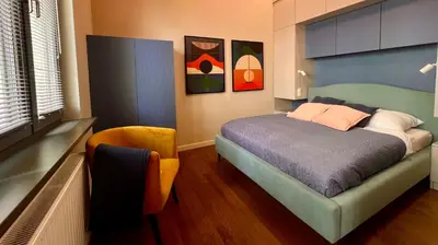 a bedroom with a bed and a chair at Smoleńsk 33 Luxury Apartment in Kraków