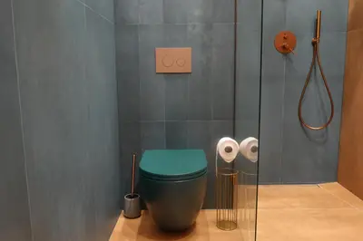a bathroom with a green toilet and a shower at Smoleńsk 33 Luxury Apartment in Kraków