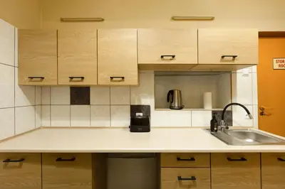 a kitchen with a sink and a coffee maker on a counter at WOW Hostel in Kraków