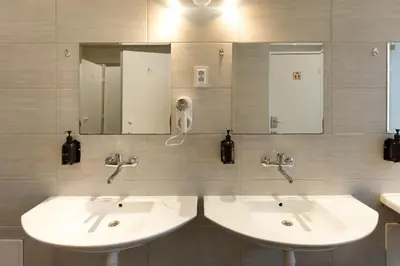 a bathroom with two sinks and a mirror at WOW Hostel in Kraków