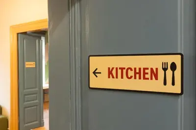 a sign on a door with a kitchen sign on it at WOW Hostel in Kraków