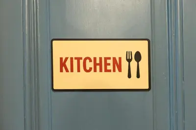 a sign on a door with a fork and spoon at WOW Hostel in Kraków