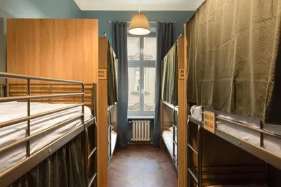 a room with three bunk beds and a window at WOW Hostel in Kraków
