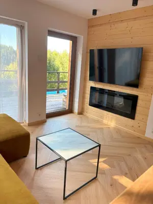 a living room with a glass coffee table and a flat screen tv at Apartament pod lasem 2 - przy szlaku na Turbacz, w pobliżu wyciągów narciarskich in Nowy Targ