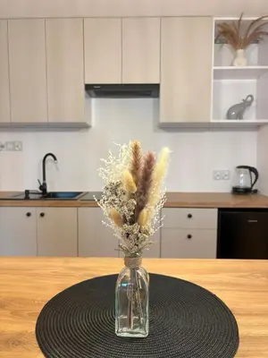 a vase filled with feathers sitting on a table at Apartament pod lasem 2 - przy szlaku na Turbacz, w pobliżu wyciągów narciarskich in Nowy Targ