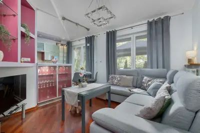 a living room with a couch and a table at Grey and Pink Two Bedroom Apartment in Cracow with Parking, Desk, Terrace and Jacuzzi Bathtub by Noclegi Renters in Kraków