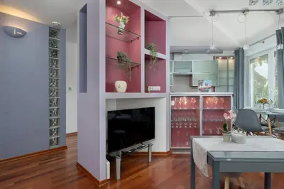 a living room with a fireplace and a tv at Grey and Pink Two Bedroom Apartment in Cracow with Parking, Desk, Terrace and Jacuzzi Bathtub by Noclegi Renters in Kraków