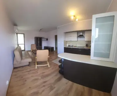 a kitchen and a living room with a counter top at Apartament Lea in Kraków