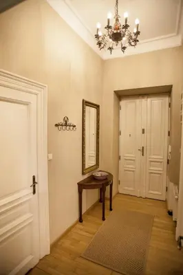 a hallway with a table and a mirror and a door at Large Apartment near Castle and Main Square in Kraków