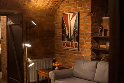 a living room with a couch and a brick wall at Large Apartment near Castle and Main Square in Kraków