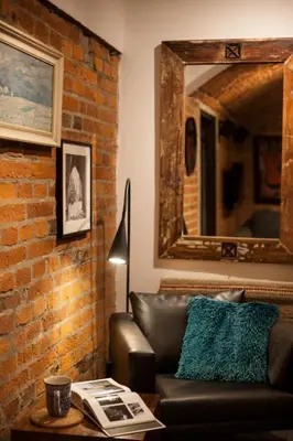 a living room with a leather couch and a mirror at Large Apartment near Castle and Main Square in Kraków