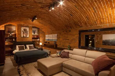 a room with a couch and a bed in a brick wall at Large Apartment near Castle and Main Square in Kraków