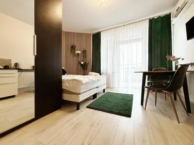a bedroom with a bed and a table with a green curtain at Batorego loft - 5 minutes to Main Square in Kraków