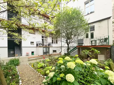 a garden with flowers in front of a building at Batorego loft - 5 minutes to Main Square in Kraków