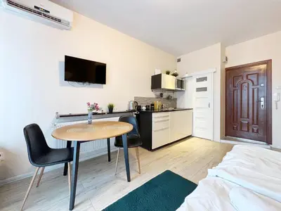 a small room with a table and a kitchen at Batorego loft - 5 minutes to Main Square in Kraków