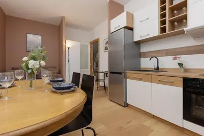 a kitchen with a wooden table and a dining room at One-Bedroom Kazimierz Apartment for Home Office Starowiślna by Noclegi Renters in Kraków