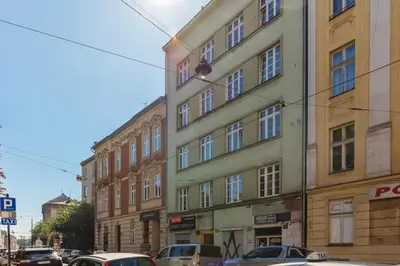 a tall building with cars parked in front of it at One-Bedroom Kazimierz Apartment for Home Office Starowiślna by Noclegi Renters in Kraków