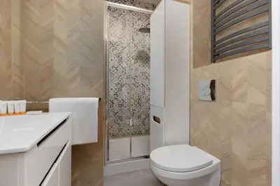 a white bathroom with a toilet and a shower at One-Bedroom Kazimierz Apartment for Home Office Starowiślna by Noclegi Renters in Kraków