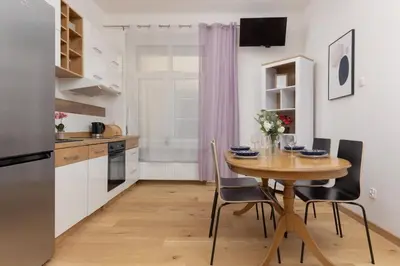 a kitchen and dining room with a wooden table and chairs at One-Bedroom Kazimierz Apartment for Home Office Starowiślna by Noclegi Renters in Kraków