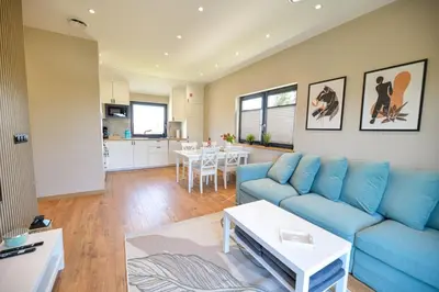 a living room with a blue couch and a table at Sun & Garden View in Oświęcim