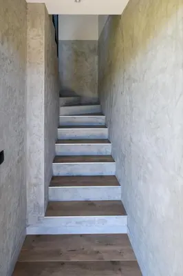 a staircase in a house with concrete walls and wooden floors at Sun & Garden View in Oświęcim