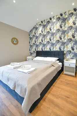 a bedroom with a large bed with a wall at Sun & Garden View in Oświęcim