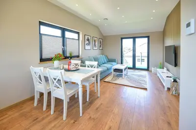 a living room with a table and a couch at Sun & Garden View in Oświęcim