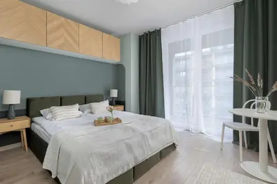 a bedroom with a bed and a large window at Apartament z 2 Sypialniami Kraków Parking Blisko Tauron Arena by Noclegi Renters in Kraków