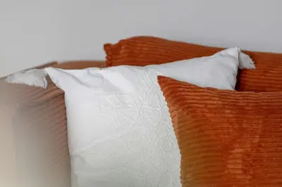 a group of pillows sitting on a bed at Apartament z 2 Sypialniami Kraków Parking Blisko Tauron Arena by Noclegi Renters in Kraków