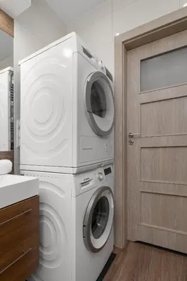 a laundry room with a washer and dryer next to a door at Apartament z 2 Sypialniami Kraków Parking Blisko Tauron Arena by Noclegi Renters in Kraków