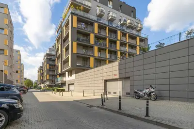 a motorcycle parked in front of a tall building at Apartament z 2 Sypialniami Kraków Parking Blisko Tauron Arena by Noclegi Renters in Kraków