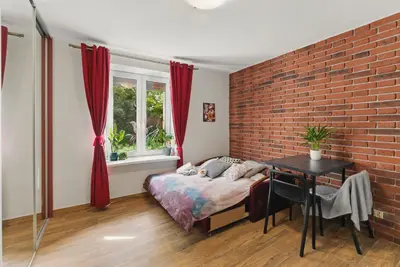 a bedroom with a bed and a brick wall at Langiewicza paradise in Kraków