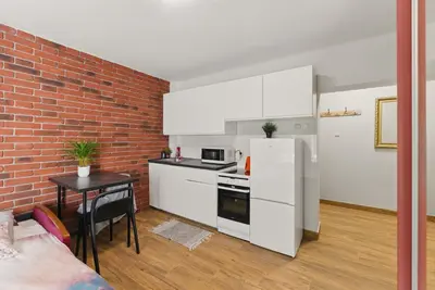 a kitchen with white appliances and a brick wall at Langiewicza paradise in Kraków