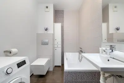 a white bathroom with a sink and a tub and a toilet at Studio z Parkingiem i Balkonem w Krakowie by Rent like home in Kraków