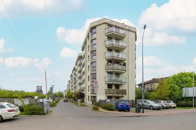a tall building with cars parked in front of it at Studio z Parkingiem i Balkonem w Krakowie by Rent like home in Kraków