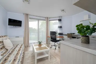 a living room with a couch and a table at Studio z Parkingiem i Balkonem w Krakowie by Rent like home in Kraków