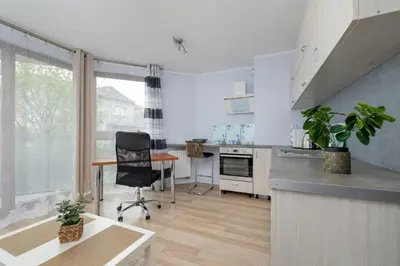 a kitchen with a desk and a chair in a room at Studio z Parkingiem i Balkonem w Krakowie by Rent like home in Kraków