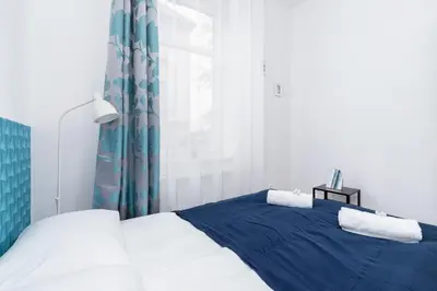 a bedroom with a blue and white bed and a window at Apartment Bosacka Cracow by Noclegi Renters in Kraków