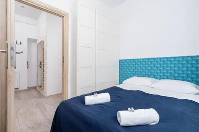 a bedroom with a blue bed with two towels on it at Apartment Bosacka Cracow by Noclegi Renters in Kraków