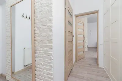 a hallway with white walls and wooden doors at Apartment Bosacka Cracow by Noclegi Renters in Kraków