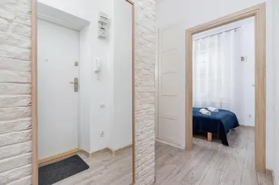 a hallway with a mirror and a bed in a room at Apartment Bosacka Cracow by Noclegi Renters in Kraków