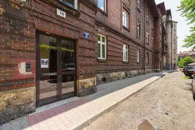 a brick building with a store window on a street at Apartment Bosacka Cracow by Noclegi Renters in Kraków