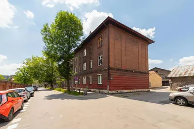 a brick building with cars parked in a parking lot at Apartment Bosacka Cracow by Noclegi Renters in Kraków