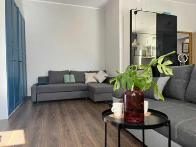 a living room with a couch and a table at Traugutta 24 Przytulny Apartament z Biurkiem i Sypialnią by Noclegi Renters in Kraków