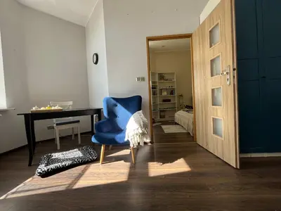 a room with a blue chair and a desk at Traugutta 24 Przytulny Apartament z Biurkiem i Sypialnią by Noclegi Renters in Kraków