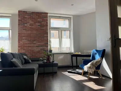 a living room with a couch and a blue chair at Traugutta 24 Przytulny Apartament z Biurkiem i Sypialnią by Noclegi Renters in Kraków