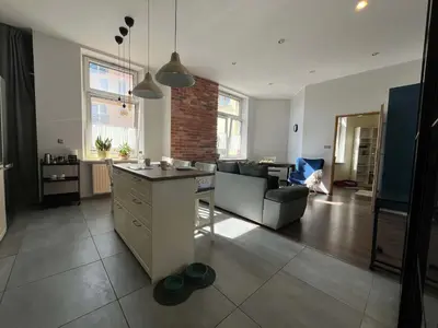 a kitchen and living room with a couch and a table at Traugutta 24 Przytulny Apartament z Biurkiem i Sypialnią by Noclegi Renters in Kraków