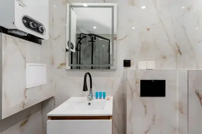 a bathroom with a sink and a mirror at Sereno Vista Apartment by BookingHost in Kraków